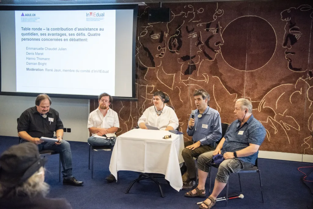 Podiumsdiskussion mit von links nach rechts: Hanno Thomann, Damian Bright, Emmanuelle Chaudet Julien, Moderator René Jaun und Denis Maret diskutieren über die Vorteile und Herausforderungen des Assistenzbeitrags im Alltag © Agile/Mark Henley